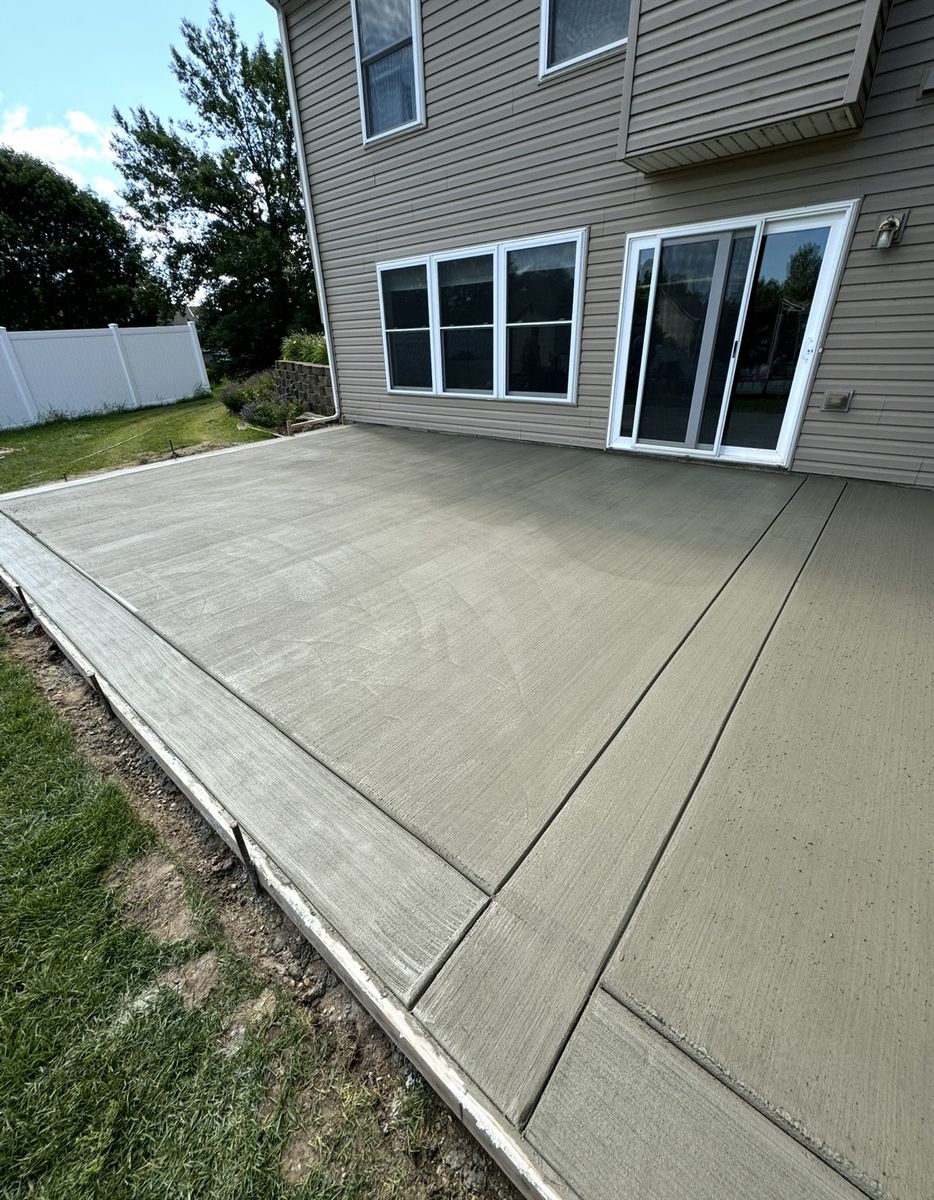 Broom finished concrete patio poured across the back of a two story home