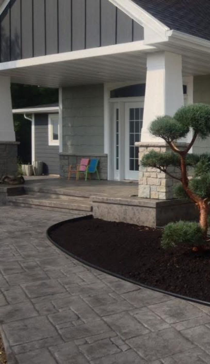 Stamped concrete front walk and steps leading to a covered entry