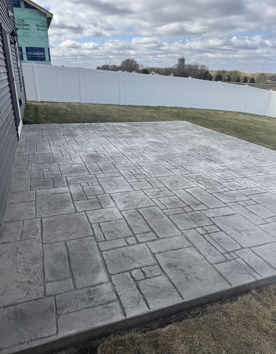 Large ashlar pattern stamped concrete patio off the side of a home