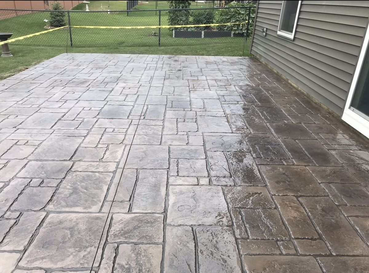 Ashlar pattern stamped concrete patio along the side of a house
