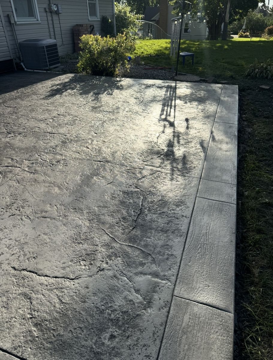 Stone texture stamped concrete patio with a wood plank border