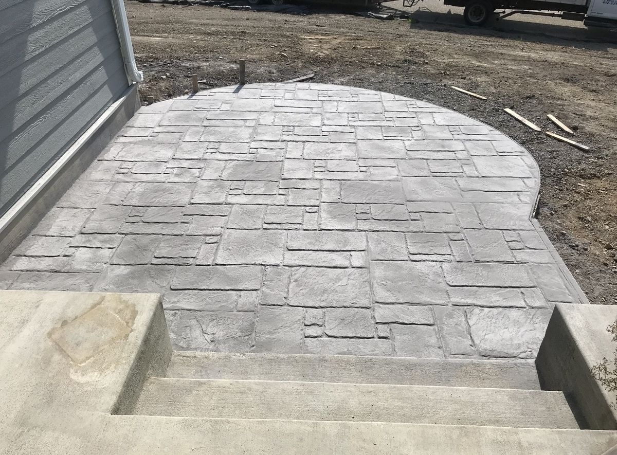 Ashlar stamped concrete patio with a radius edge at the bottom of walkout steps